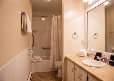 Bathroom in the Guest House with a shower-over-bath, vanity and large mirror