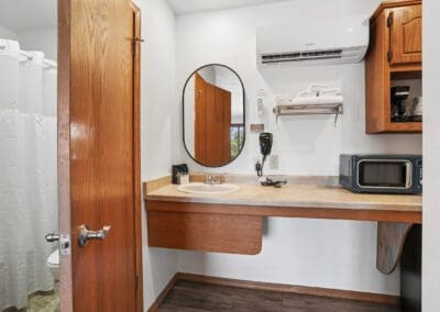 The bathroom door and vanity area of a Two Queen Room at Parkside Inn