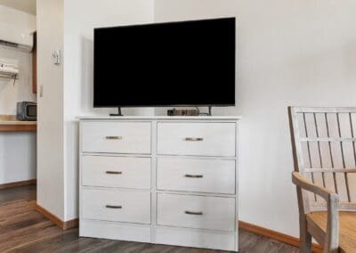 Flat-screen television on a white dresser in a Two Queen Room